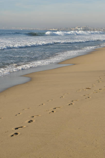 istock Footsteps in the Sand with Wave Breaking Vertical 1197594980
