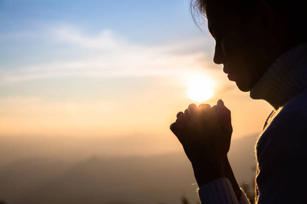 woman praying in the morning on the sunrise background. christianity concept. pray background. faith hope love concept. - cross cross shape christianity hope imagens e fotografias de stock