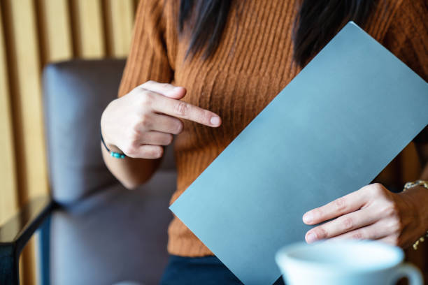 istock woman is holding and presenting an empty page as template texture 1197599523