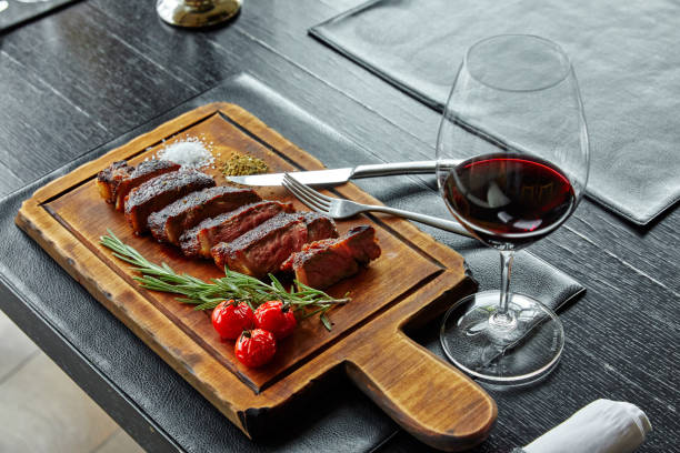 istock fried boiled pork, cut into slices, lying on a wooden board, decorated with tomatoes, tarragon, herbs 1197601792