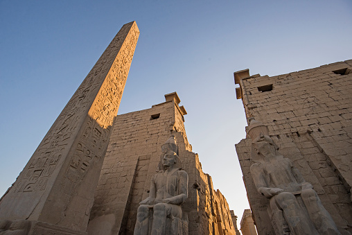Obelisk column with hieroglyphic carvings at entrance to ancient egyptian Luxor Temple