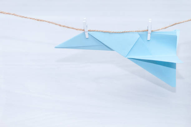 istock Blue paper plane  hanging on a thread. Tourism or travel concept. 1197607622