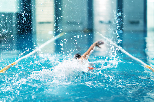 professional swimmer doing exercise in indoor swimming pool.