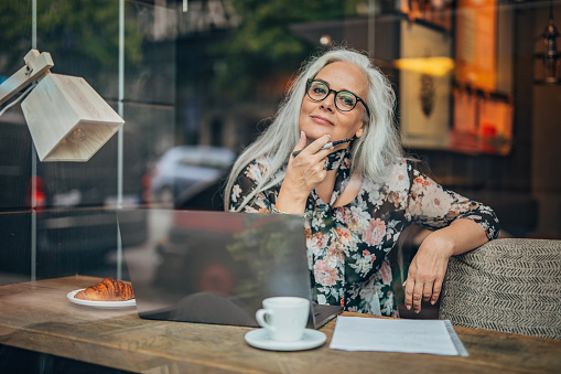Vieja mujer de negocios sentada en el café solo photo