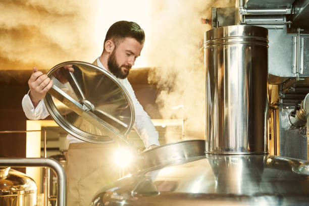 istock Brewer inspecting process of brewing beer with steam. 1197613694