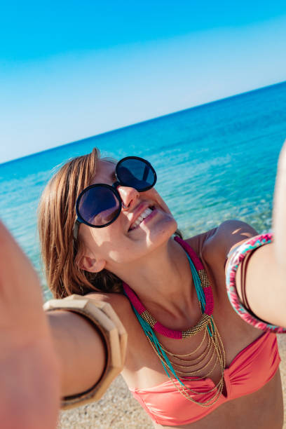 istock Smiling girl making selfie on a sunny beach. 1197617386
