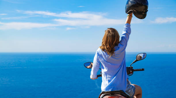 istock Woman with scooter looking at the distant sea horizon. 1197618475