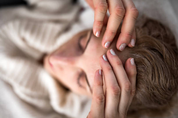 istock Woman with sinuses problem, stomach and head issues at home on a couch, being sick. 1197618670