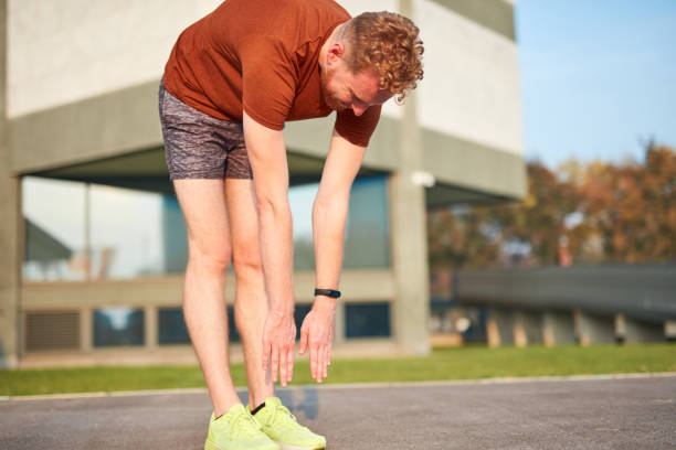 istock Young man exercising / stretching in urban park. 1197619468