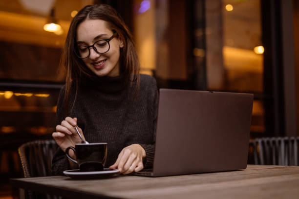 istock Woman sitting in cafe on coffee break and using laptop 1197619500