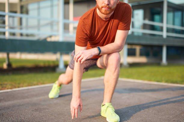 istock Young man exercising / stretching in urban park. 1197619665