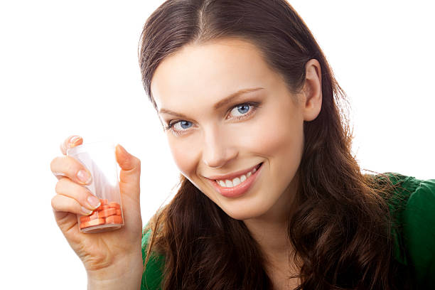 istock Smiling woman showing bottle with pills, isolated 119762072