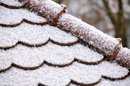 Pattern of a closeup of a roof with plane tiles covered with a thin layer of snow. Seen in Germany in December
