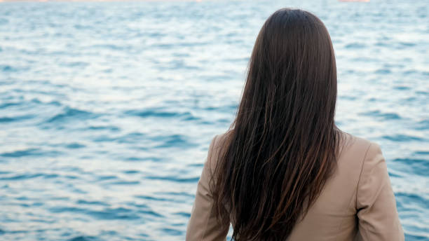 istock lady enjoys seascape standing on opposite shore on vacation 1197622181