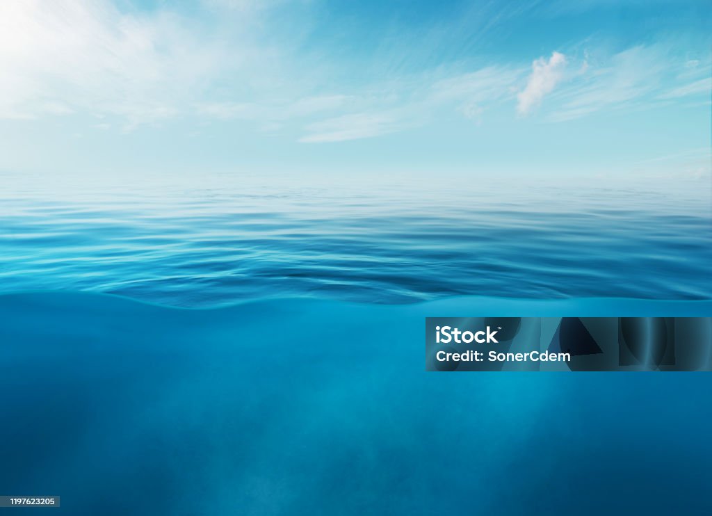 Blue sea or ocean water surface and underwater with sunny and cloudy sky Blue sea or ocean water surface and underwater with sunny and cloudy sky. Sea Stock Photo