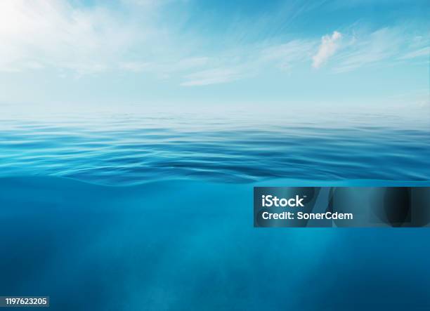 Blue Sea Or Ocean Water Surface And Underwater With Sunny And Cloudy Sky Stock Photo - Download Image Now