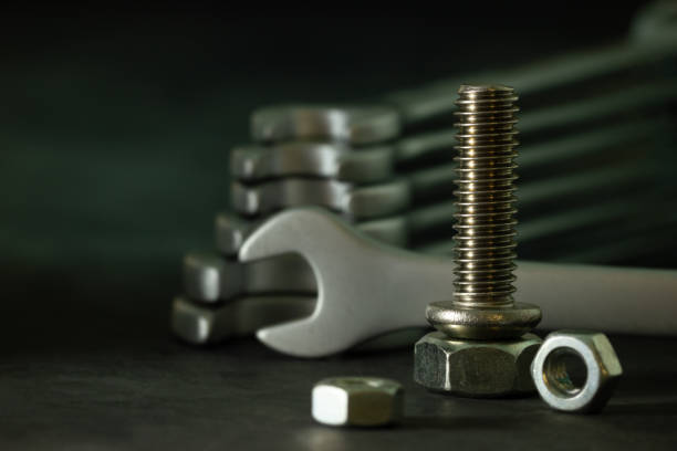 istock Bolt nuts and wrench on cement floor in darkness. 1197630642