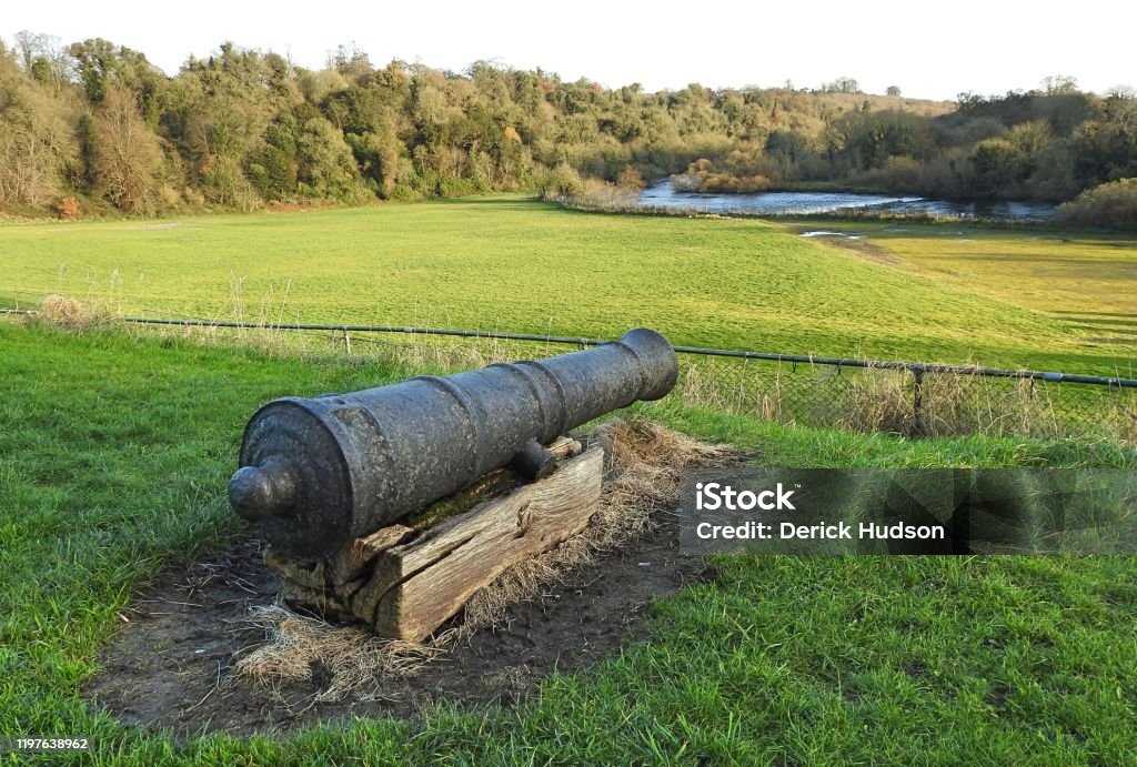 Old cannon Old cannon pointing across a natural amphitheatre field, used by Slane Castle as a concert venue. The River Boyne is in the background, in Slane, County Meath, Ireland. County Meath Stock Photo