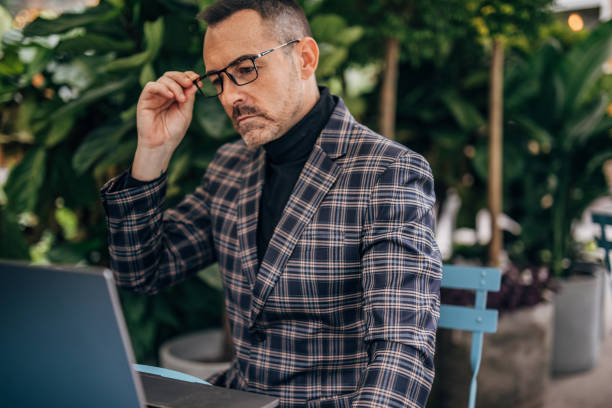 istock Businessman using laptop in sidewalk cafe 1197638998