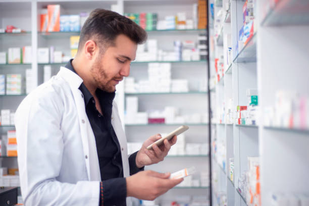istock Portrait of a pharmacist holding a pill using smart phone in pharmacy 1197647621