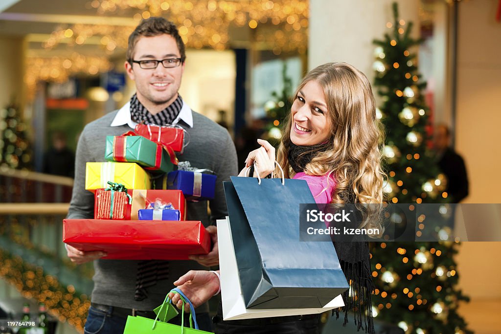 Пара с рождественские подарки и bags in mall - Стоковые фото Ёлочные игрушки роялти-фри