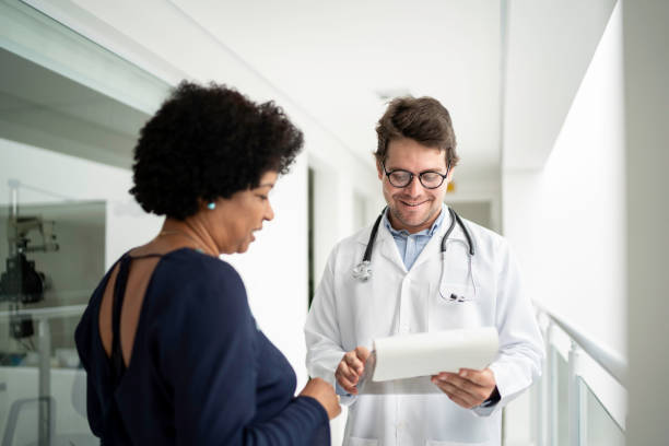 doctor explaining medical exam to a patient at hospital - doctor patient greeting talking imagens e fotografias de stock