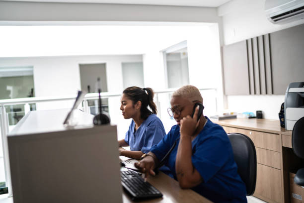 sekretarka pracująca w recepcji szpitala - customer service representative service african descent receptionist zdjęcia i obrazy z banku zdjęć