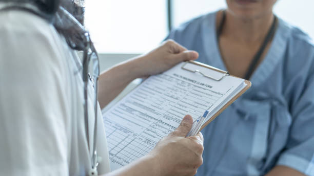 formulaire de réclamation d'assurance maladie patient dans les mains de médecin ou d'infirmière pour la couverture d'assurance-maladie et le traitement médical de la maladie, des dommages d'accident et admis dans le service d'hôpital - assurance maladie photos et images de collection