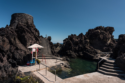 view of the rocky seaside in terceira with natural pool to have a bath, seascape in azores, portugal.