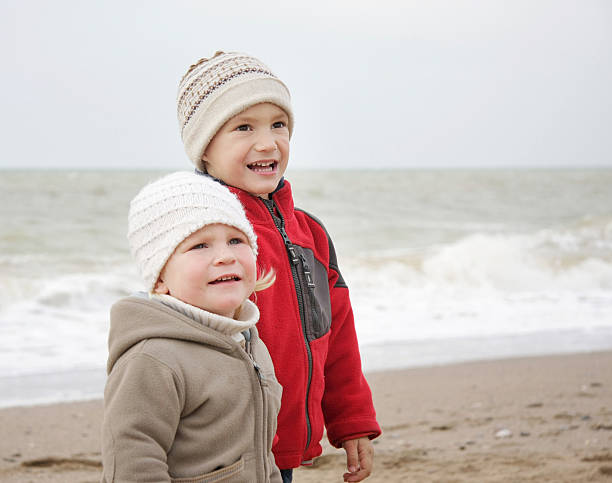 istock two children on winter sea background 119765401