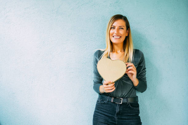 Cute Woman is Holding Heart Shaped Gift Box