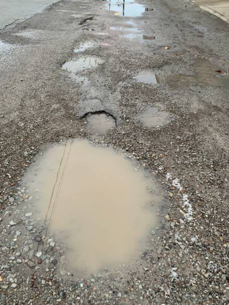 istock Side Street with Rain Filled Potholes 1197655861