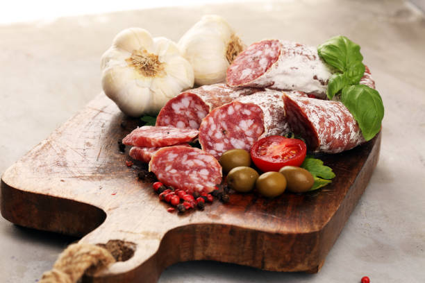 istock thinly sliced salami on a wooden texture on the background. 1197656975