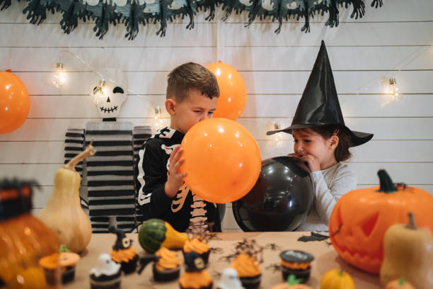istock Lovely siblings blowing balloons for Halloween 1197665087