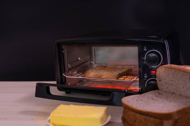 istock Black micro electric oven with whole wheat bread and butter. 1197668160