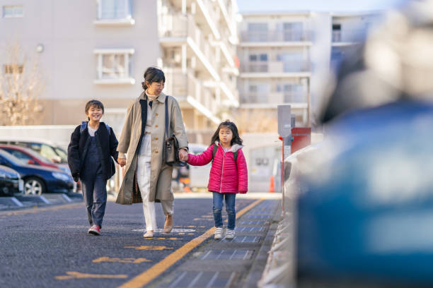 Working mother and sisters walking to car