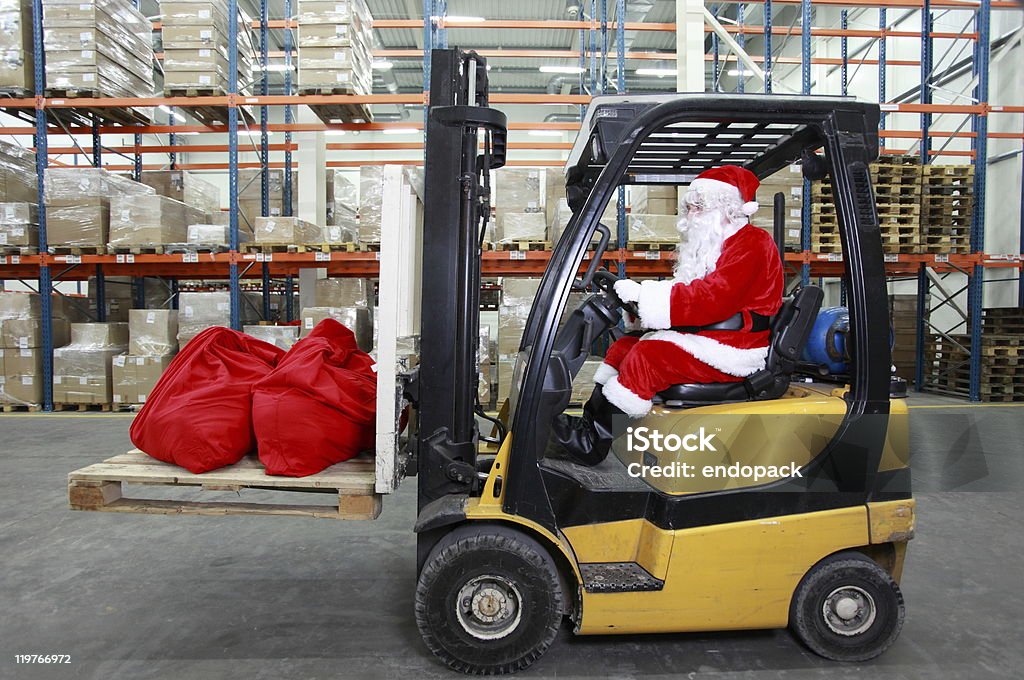 Santa Claus jako operator wózka widłowego w pracy w magazynie - Zbiór zdjęć royalty-free (Boże Narodzenie)
