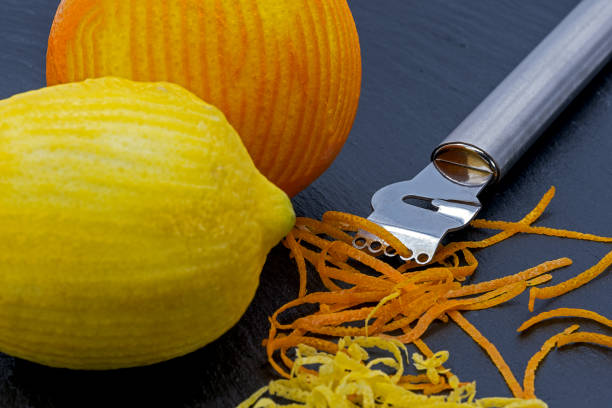 лимон и апельсин с цедрой и пилингом - grater grated peel ingredient стоковые фото и изображения