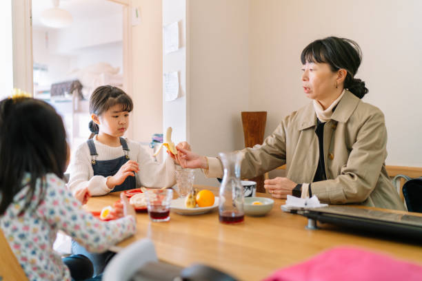 istock Working mother having breakfast with her daughters in the morning before they leave home 1197670108