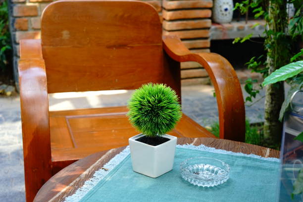 Decorative Artificial Green Plants in White Pots on table.