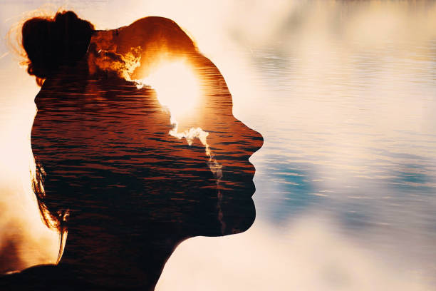 sun peeks out from behind the clouds in woman's head - spirituality imagens e fotografias de stock