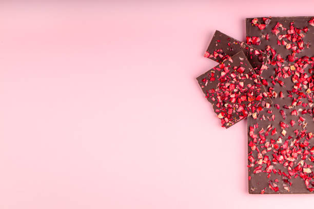 istock Chocolate with Pieces of Dried Strawberries Lies a Stack on Pink Background 1197670898