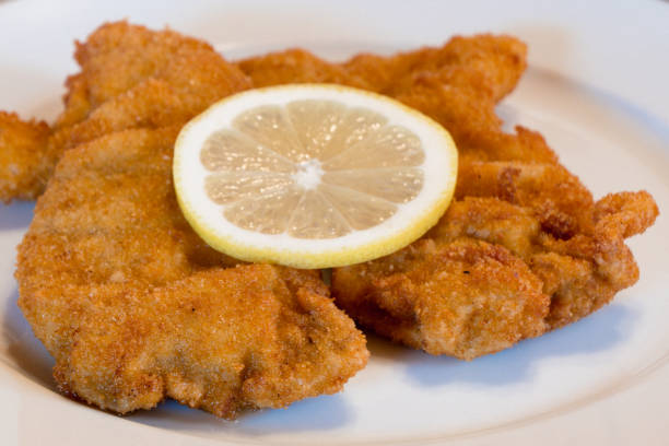 schnitzel vienesa en un plato blanco con limón - food elegance cutlet restaurant fotografías e imágenes de stock