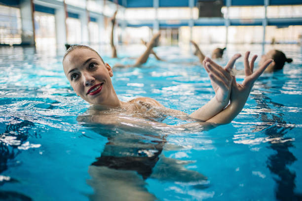 istock Cheerful young woman performing in a swimming pool 1197675408