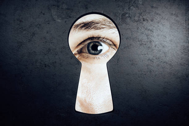 Male eye in keyhole Male eye looking out of keyhole opening in concrete wall. Access and vision concept keyhole photos stock pictures, royalty-free photos & images