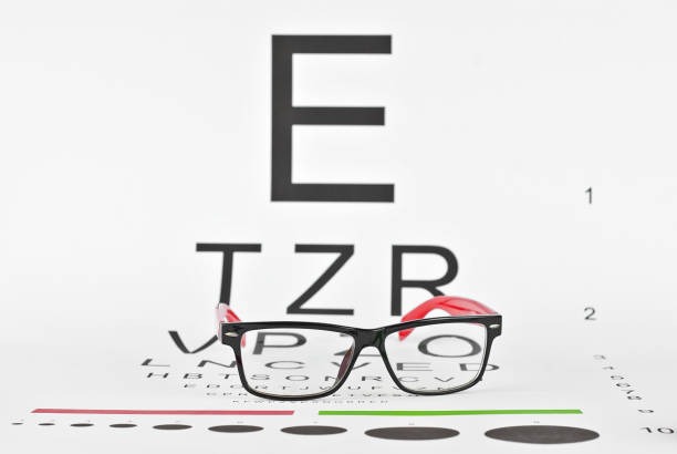 istock Glasses on a white background. Background with letters for vision test. 1197678013