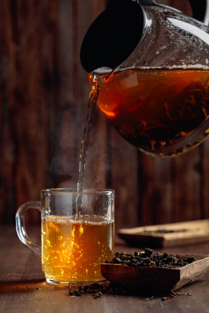 istock Fresh green tea is poured from a teapot into a mug. 1197678059