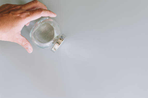 istock man hand place empty glass jar on grey back ground 1197678232