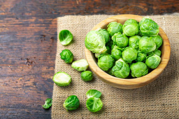 istock uncooked brussels sprouts in a plate on a wooden table. 1197681085