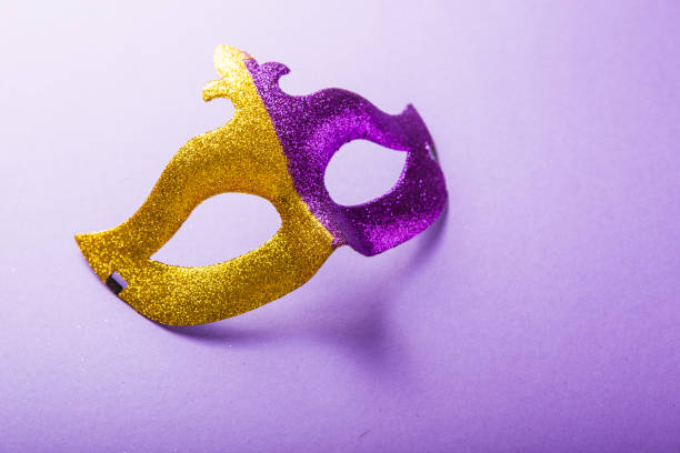 A festive, colorful group of mardi gras or carnivale mask on a purple background. Venetian masks. A festive, colorful group of mardi gras or carnivale mask on a purple background. Venetian masks. gawdy stock pictures, royalty-free photos & images